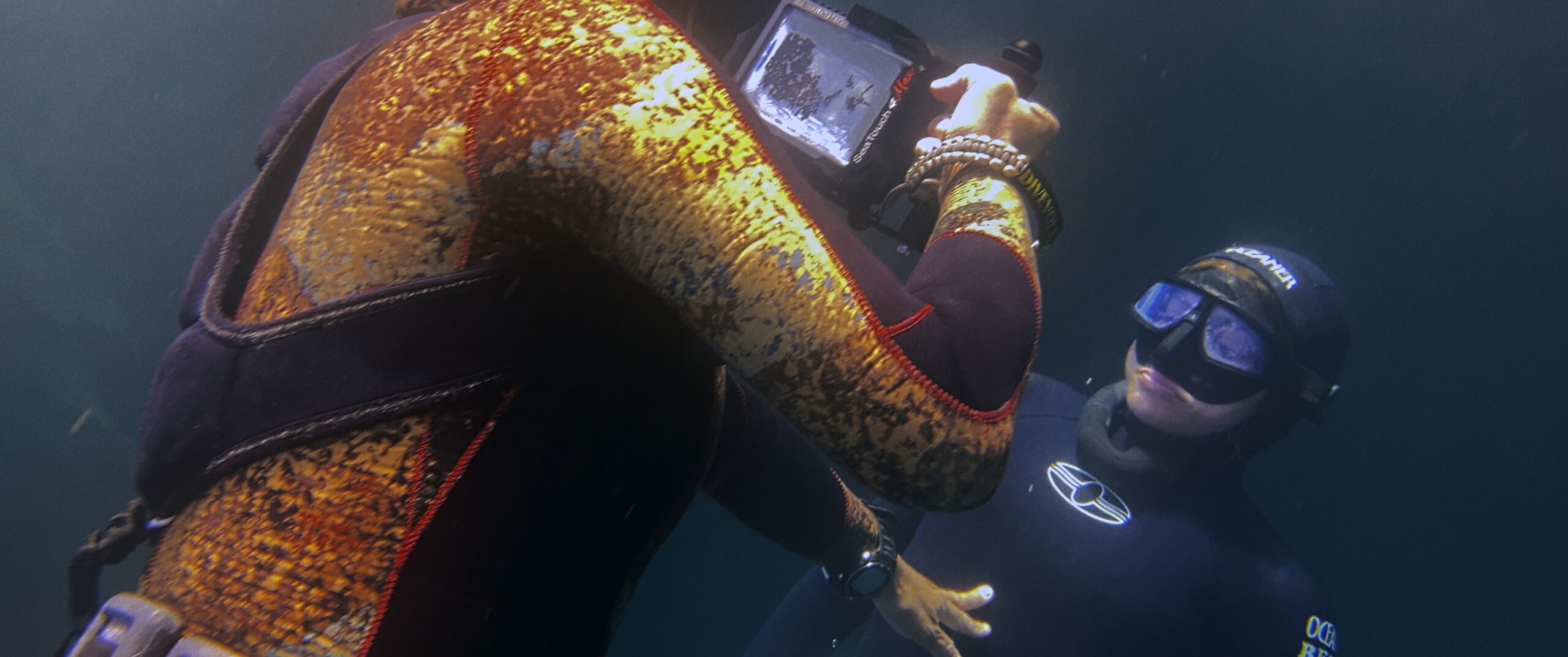 Scuba diver shooting underwater mobile video of a freediver with Filmic Pro
